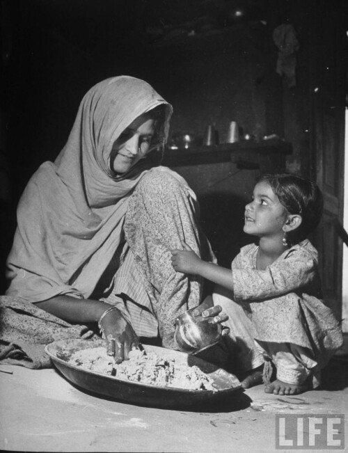 Indian-moneylender-wife-a-member-of-Bania-a-subcaste-of-Vaisya-preparing-chapatis-type-of-bread-as-her-pretty-young-daughter-looks-on.-at-home.jpg
