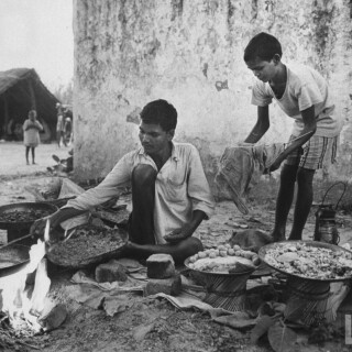 Indian-vendor-at-his-food-stall-at-temple-outside-of-village-of-Gaonkhera---1962