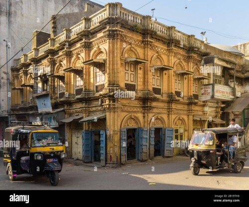 junagadh-gujarat-india-december-2018-a-beautiful-yellow-building-with-arcaded-windows-and-vintage-wooden-doors-in-the-old-market-area-2B19TH3.jpg
